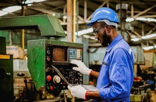 Travailleur utilisant une machine dans un atelier industriel